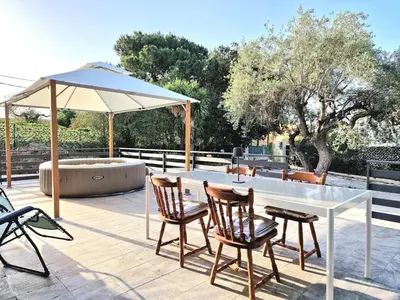a table with chairs and an umbrella on a patio at Villa Giacoma hot tub and garden in Mandra Capreria