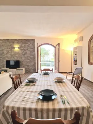 a dining room with a table and chairs and a living room at Villa Giacoma hot tub and garden in Mandra Capreria
