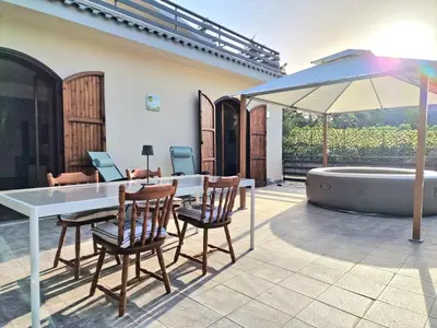 a patio with a table and chairs and an umbrella at Villa Giacoma hot tub and garden in Mandra Capreria