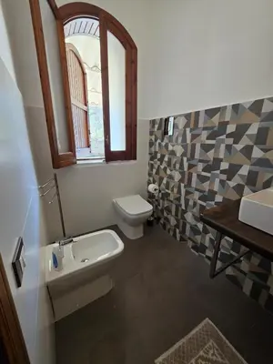 a bathroom with a toilet and a sink and a window at Villa Giacoma hot tub and garden in Mandra Capreria