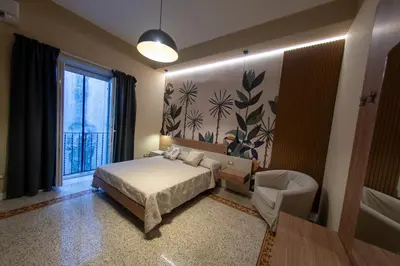 a bedroom with a bed and a chair and a window at Casa SMART in Palermo
