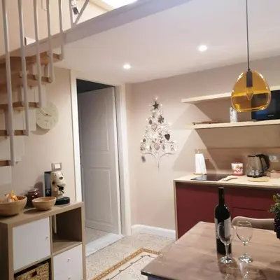 a kitchen with a staircase and a table with a wine bottle at Casa SMART in Palermo