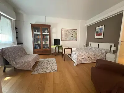 a bedroom with two beds and a chair and a desk at una casa tranquilla in Palermo
