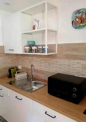 a kitchen counter with a sink and a microwave at una casa tranquilla in Palermo