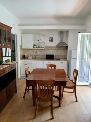 a kitchen with a wooden dining table and chairs at una casa tranquilla in Palermo