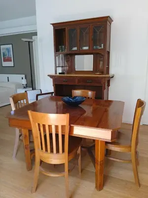 a wooden dining room table with chairs and a cabinet at una casa tranquilla in Palermo