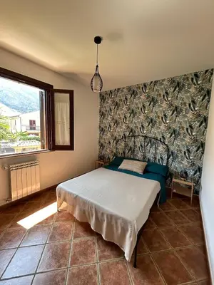 a bedroom with a bed in the corner of a room at Villa Irene in Isola delle Femmine