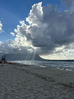 a beach with a cloudy sky and the ocean at Villa Irene in Isola delle Femmine