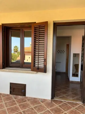 a room with windows and a view of a patio at Villa Irene in Isola delle Femmine