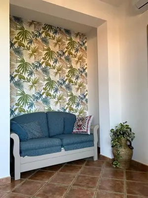 a blue couch in a room with a wall at Villa Irene in Isola delle Femmine