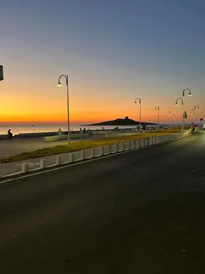 a street with street lights and the beach at sunset at Villa Irene in Isola delle Femmine