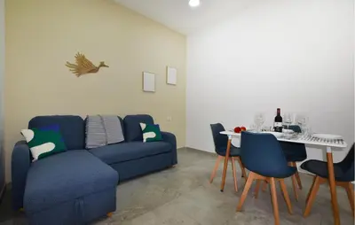 a living room with a blue couch and a table at Lovely Home In Isola Delle Femmine With Wifi in Isola delle Femmine