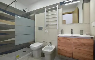 a bathroom with a toilet and a sink and a mirror at Lovely Home In Isola Delle Femmine With Wifi in Isola delle Femmine