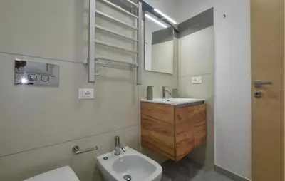 a bathroom with a sink and a toilet and a mirror at Lovely Home In Isola Delle Femmine With Wifi in Isola delle Femmine