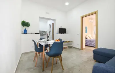 a kitchen and living room with a table and chairs at Lovely Home In Isola Delle Femmine With Wifi in Isola delle Femmine