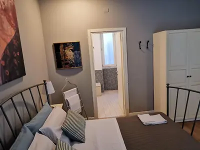 a bedroom with a bed and a door leading to a bathroom at B&B Museo Salinas in Palermo