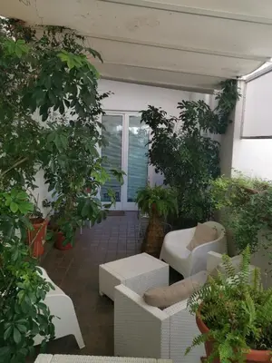 a patio with white furniture and potted plants at B&B Museo Salinas in Palermo