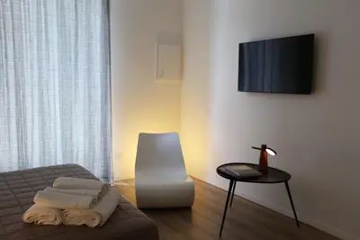 a room with a bed and a table and a television at Devalù Politeama - Elegante appartamento al Politeama in Palermo