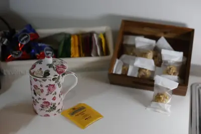 a coffee cup and a box of cookies on a table at Devalù Politeama - Elegante appartamento al Politeama in Palermo