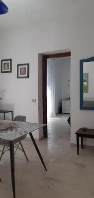 a living room with a table and a door to a room at Borgo Vivo in Palermo