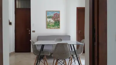 a dining room table with chairs and a painting on the wall at Borgo Vivo in Palermo