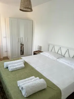 a large white bed with two towels on it at Via dei mirtilli in Carini