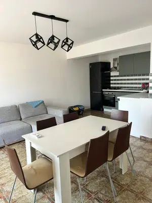 a kitchen and living room with a white table and chairs at Via dei mirtilli in Carini
