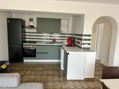 a kitchen with white cabinets and a red appliance at Via dei mirtilli in Carini