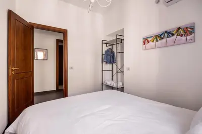a bedroom with a white bed and a closet at La Casa del Genio in Palermo