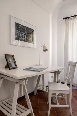 a white desk with two chairs and a lamp at La Casa del Genio in Palermo