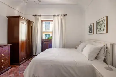 a bedroom with a white bed and a window at La Casa del Genio in Palermo
