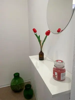a vase with flowers on a shelf with a mirror at Vicolo 25 in Cinisi