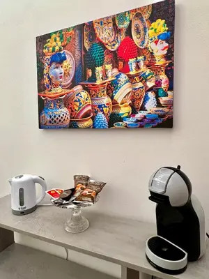 a painting hanging on a wall above a table at Vicolo 25 in Cinisi