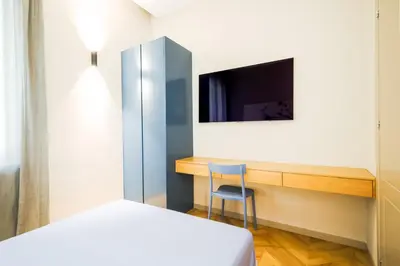 a bedroom with a bed and a desk with a television at Exclusuite Design Apartment in Palermo