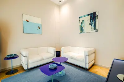 a living room with two white couches and purple tables at Exclusuite Design Apartment in Palermo