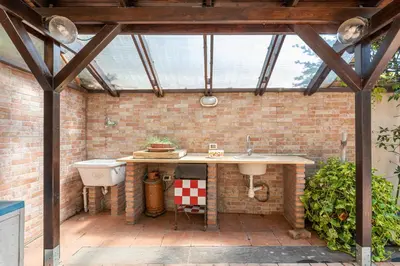 an outdoor kitchen with a sink and a glass roof at Antonio Family House a Mondello by Wonderful Italy in Palermo
