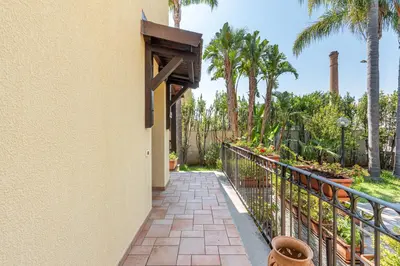 a walkway leading to a balcony with palm trees at Antonio Family House a Mondello by Wonderful Italy in Palermo