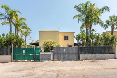 a gate in front of a house with palm trees at Antonio Family House a Mondello by Wonderful Italy in Palermo