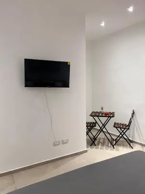 a flat screen tv on a white wall in a living room at Moonlight Rooms in Termini Imerese