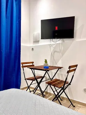 a room with a table and two chairs and a tv at Moonlight Rooms in Termini Imerese