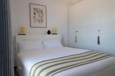 a bedroom with a white bed with a striped blanket at Nuovo appartamento sul mare immerso nel verde in Palermo