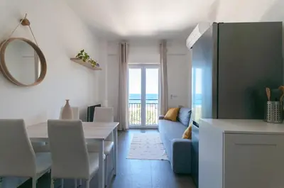 a living room with a blue couch and a table at Nuovo appartamento sul mare immerso nel verde in Palermo