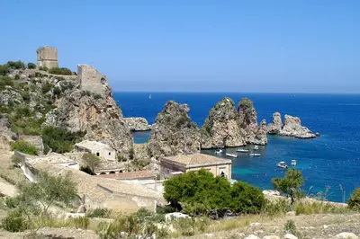 a group of boats in the water next to a castle at Case Della Baia in Castellammare del Golfo