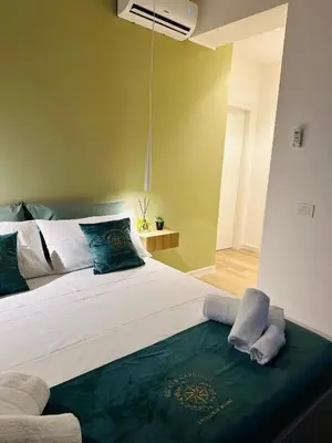 a bedroom with a large bed with green walls at Ricci & Capricci Exclusive Room in Aspra