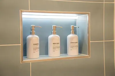 a shelf with three shampoo bottles in a bathroom at Ricci & Capricci Exclusive Room in Aspra