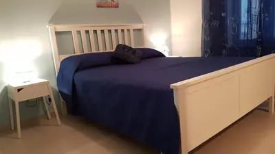 a bedroom with a bed with a blue comforter at Buonaluna B&B in Palermo