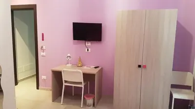 a room with a table and a tv on a purple wall at Buonaluna B&B in Palermo