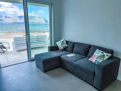 a living room with a couch and a large window at Palermo sul mare di Isola delle Femmine in Isola delle Femmine