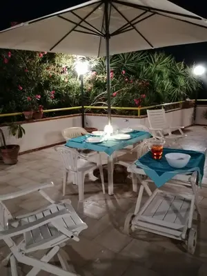 a table and chairs and an umbrella on a patio at Alta Marea Mondello - Palermo in Palermo