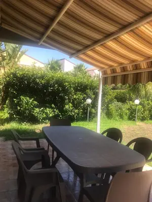 a wooden table and chairs under a pavilion at Villaggio 101 Pini in Buonfornello